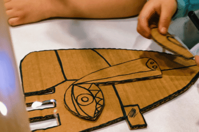 Libro Picasso para niños y manos creando máscaras cubistas
